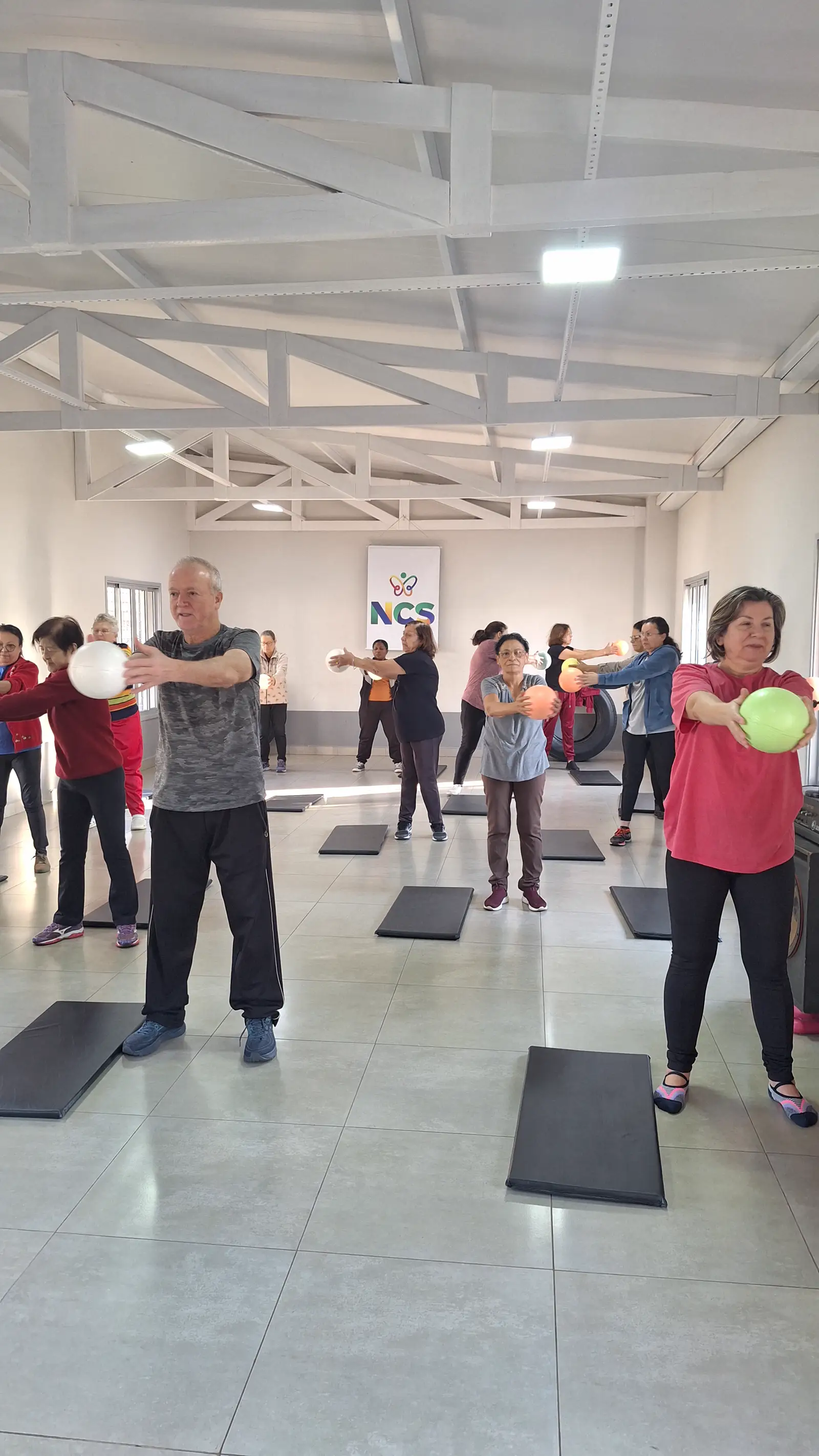 Grupo participa de uma atividade coletiva de movimento em um espaço da NCS.
